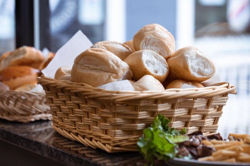 Cesta de pães sobre mesa de madeira